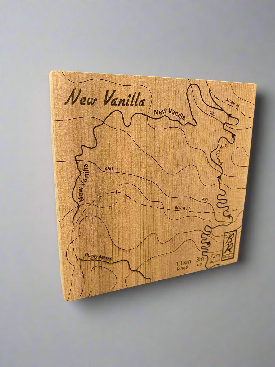A wooden map tile featuring a detailed trail map of New Vanilla in the Cumberland mountain bike trails.