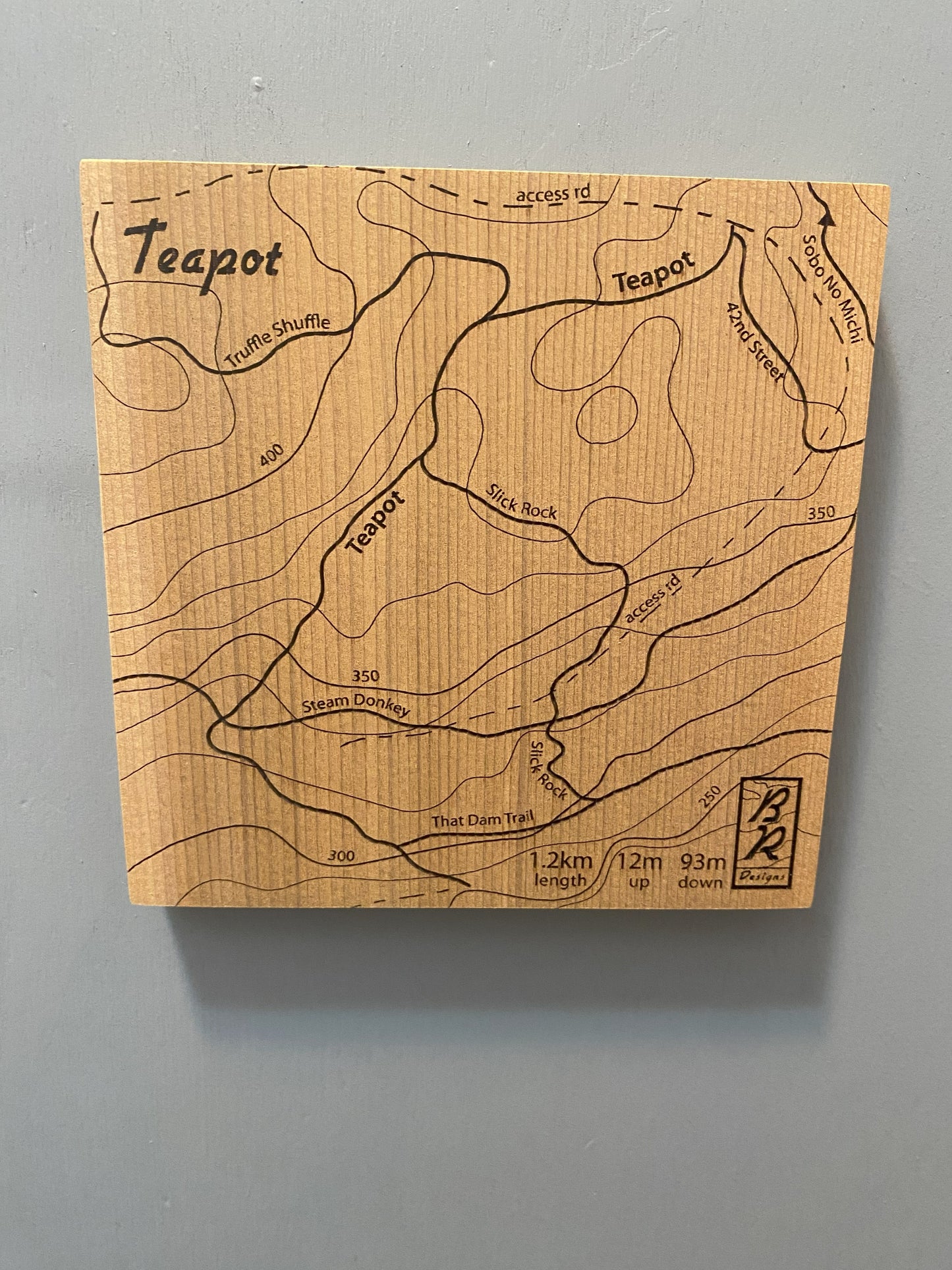 A wooden map tile featuring a detailed trail map of Teapot in the Cumberland mountain bike trails.