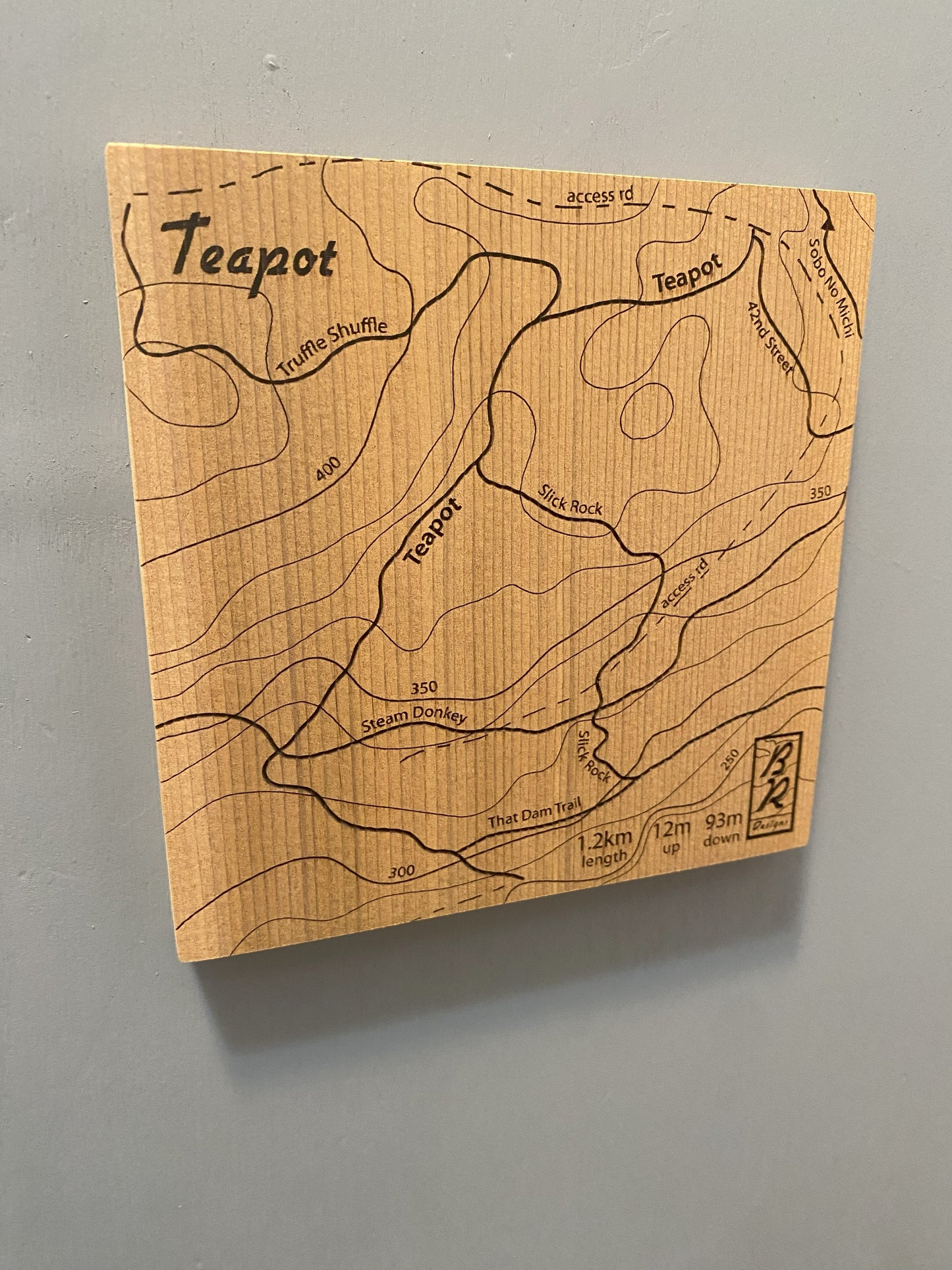A wooden map tile featuring a detailed trail map of Teapot in the Cumberland mountain bike trails.