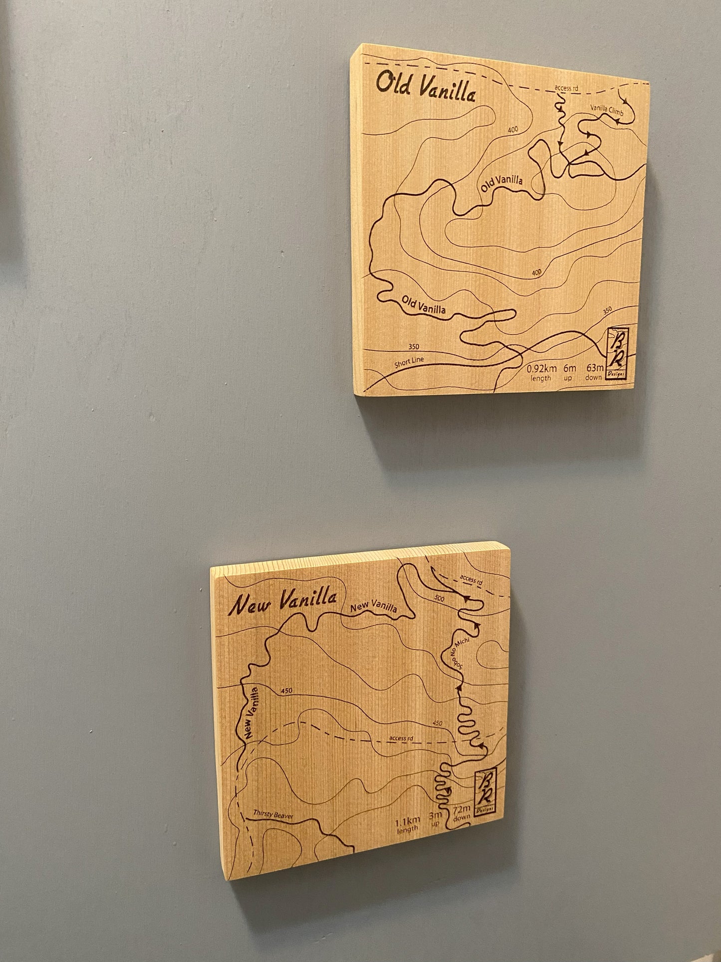 Two wooden map tiles featuring a detailed trail map of Old & New Vanillas in the Cumberland mountain bike trails.