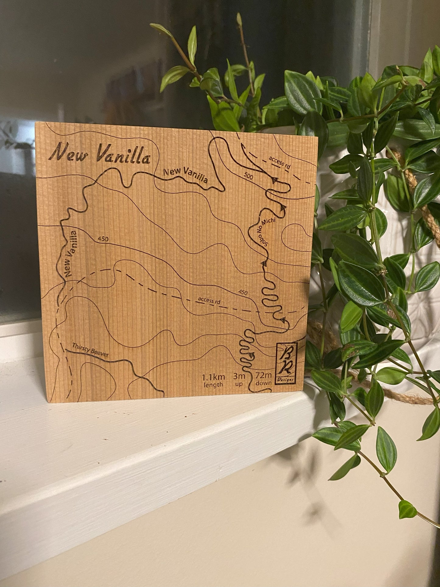 A wooden map tile featuring a detailed trail map of New Vanilla in the Cumberland mountain bike trails.