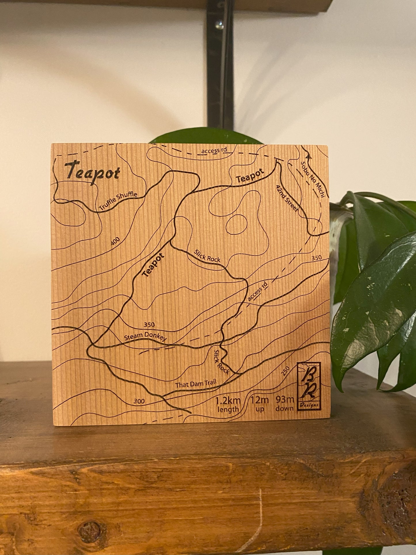 A wooden map tile featuring a detailed trail map of Teapot in the Cumberland mountain bike trails.