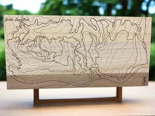 A wooden map of Jordie Lunn Mountain Bike Park, displayed on a stand, with engraved topographical lines.