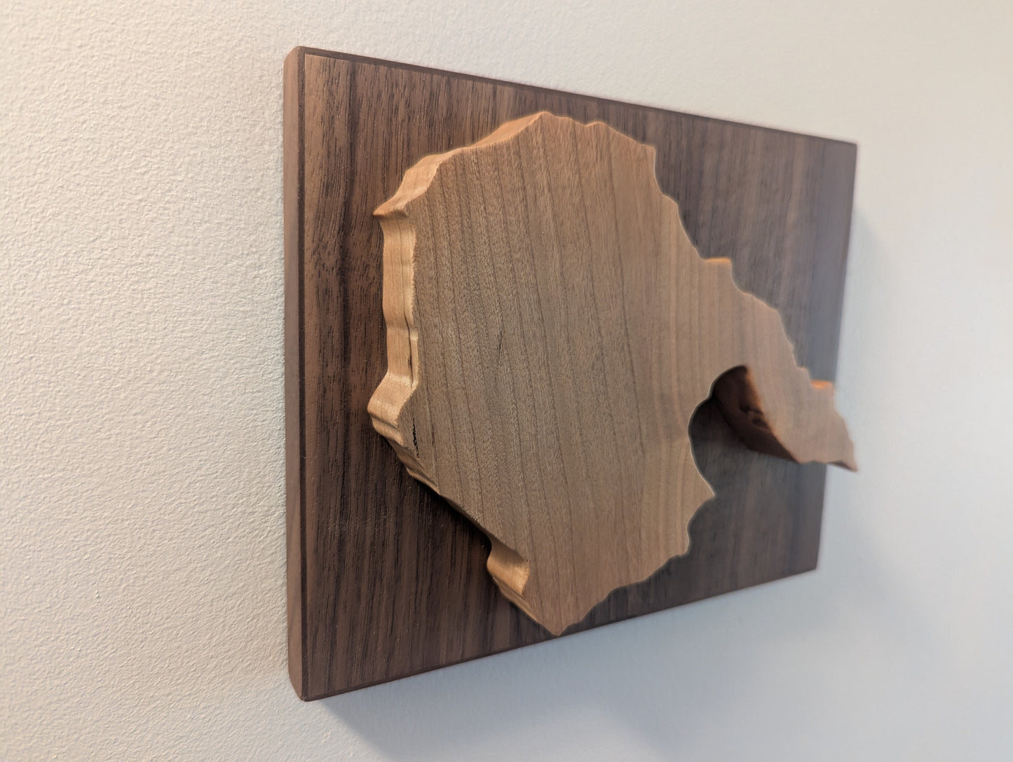 Wooden wall art with a cherry cut-out design of the Hornby Island on a walnut backer.