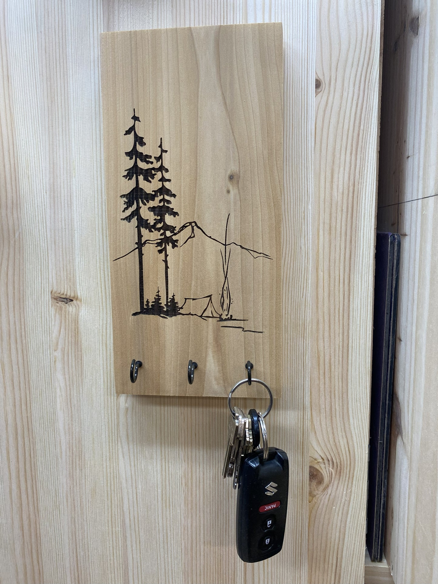 Wooden key holder with tree design on a wooden wall