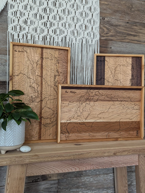 A collection of laser engraved maps displayed on a table.