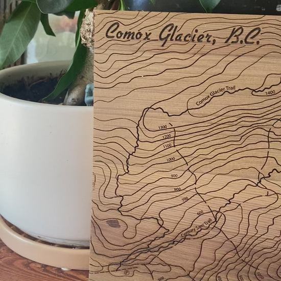 Video showing a topographic map of Comox Glacier engraved on cedar