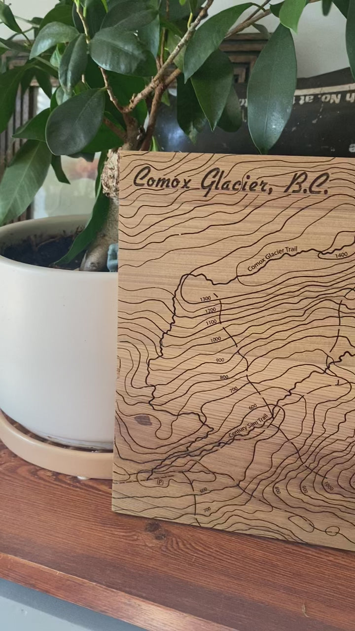 Video showing a topographic map of Comox Glacier engraved on cedar