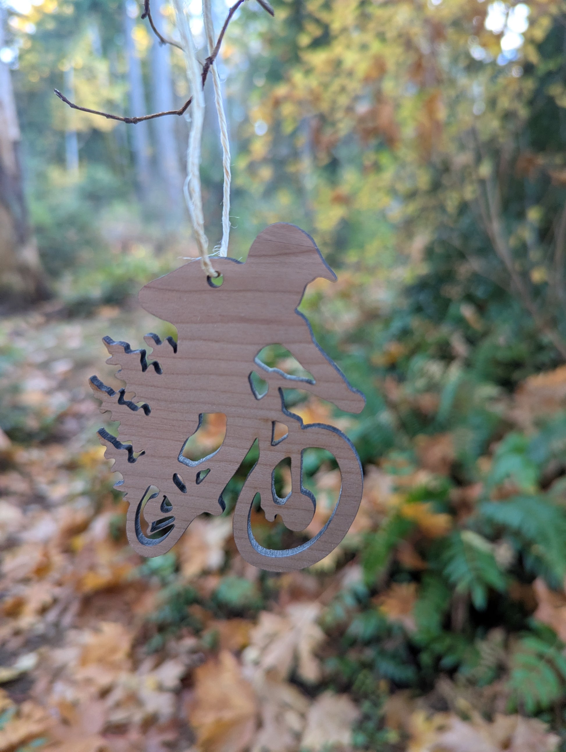 Handcrafted wooden mountain bike silhouette ornament with natural hanger, a perfect Christmas gift for cyclists and riders.